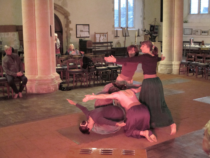 Group of 5 dancers, one kneels with head bent to florr, 2 kneel facing eachother. 2 dancers lunge, facing eachother.