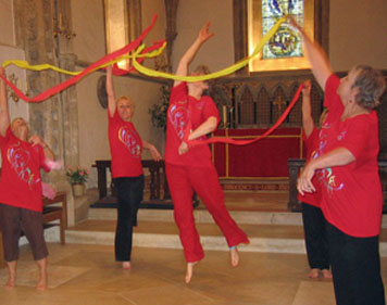 Dancers in red with red and yellow streamers