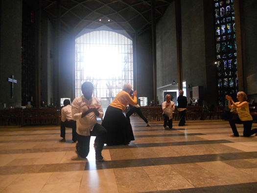 Dancer kneeling and lunging in front of a large windownging